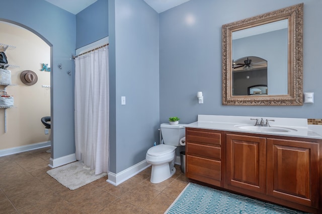 bathroom featuring ceiling fan, walk in shower, toilet, vanity, and tile patterned floors