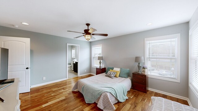 bedroom with ensuite bathroom, light wood-type flooring, and ceiling fan