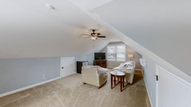 sitting room featuring ceiling fan, light colored carpet, and vaulted ceiling