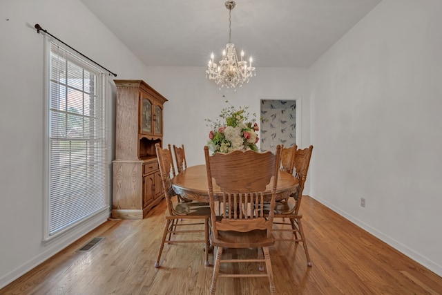 dining room with a chandelier and light wood-type flooring