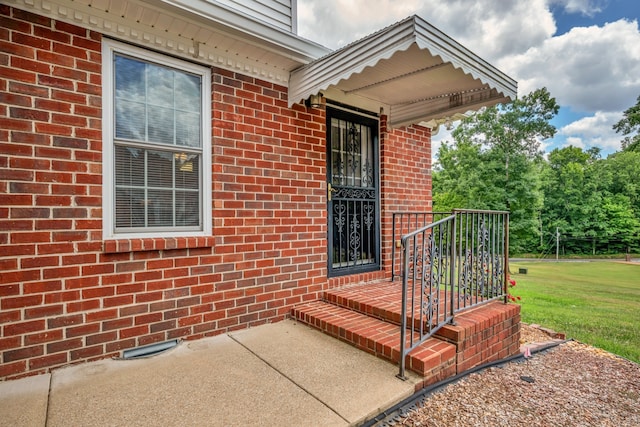 entrance to property with a lawn