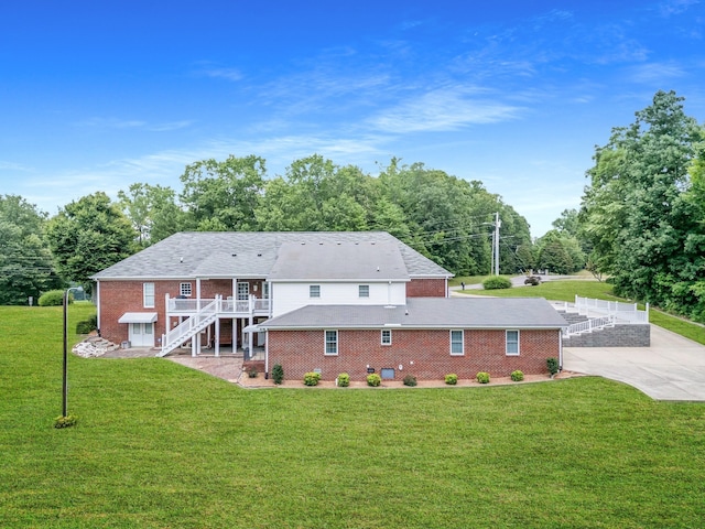 rear view of property with a deck and a lawn