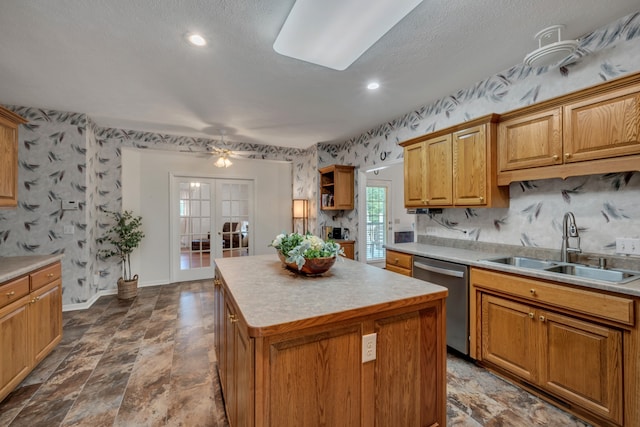 kitchen featuring a kitchen island, a textured ceiling, dishwasher, french doors, and sink