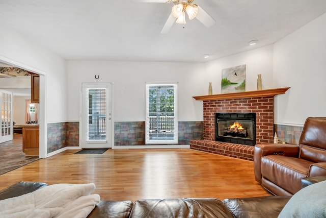 living room with hardwood / wood-style floors, a fireplace, and ceiling fan