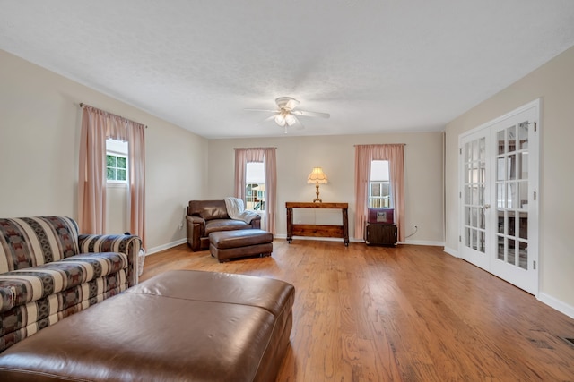 living room with french doors, light hardwood / wood-style floors, plenty of natural light, and ceiling fan