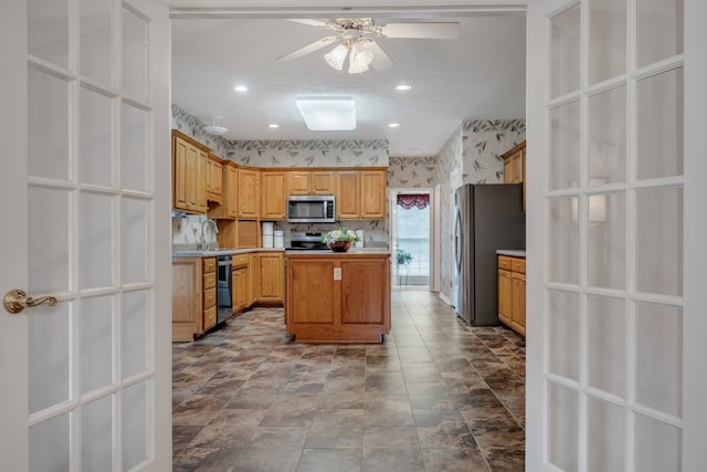 kitchen with ceiling fan, appliances with stainless steel finishes, sink, and light brown cabinetry