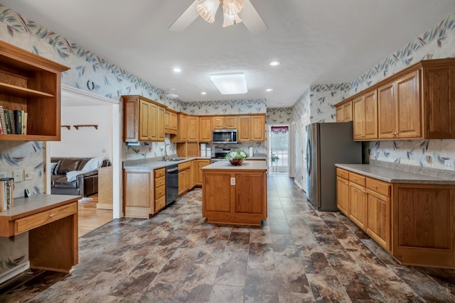 kitchen with appliances with stainless steel finishes, ceiling fan, sink, and a kitchen island