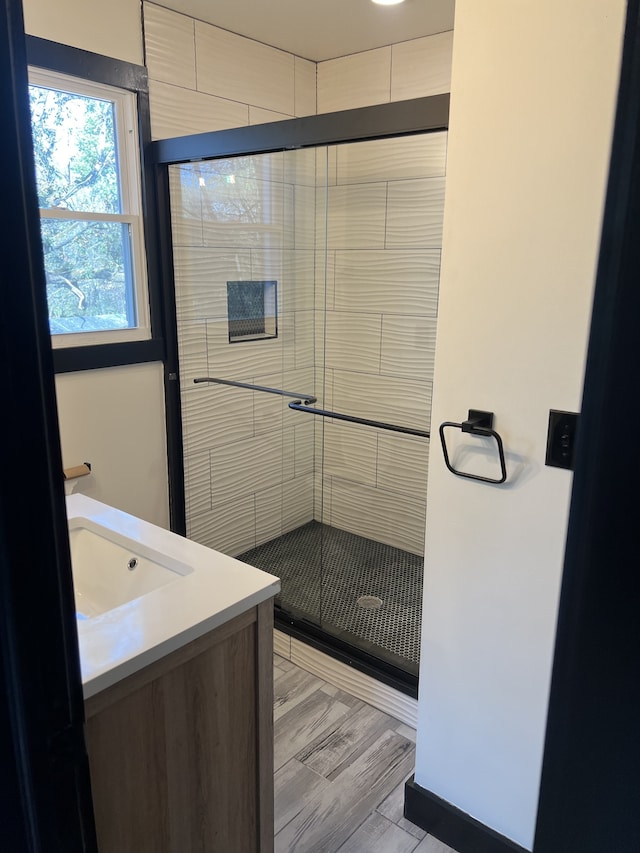 bathroom featuring vanity, an enclosed shower, and wood-type flooring