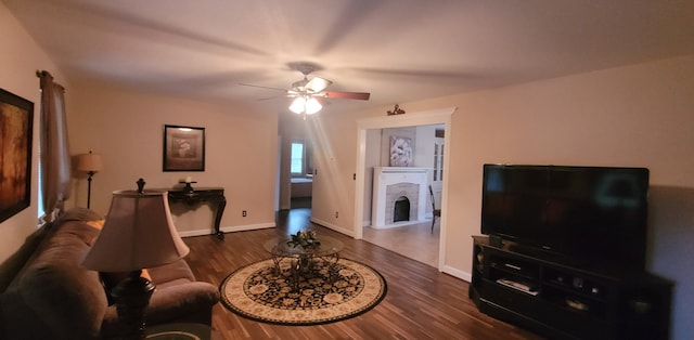 living room featuring dark wood-type flooring and ceiling fan