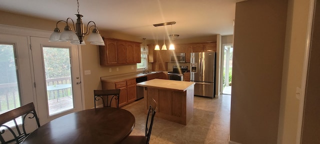 kitchen with a center island, a wealth of natural light, sink, and stainless steel appliances