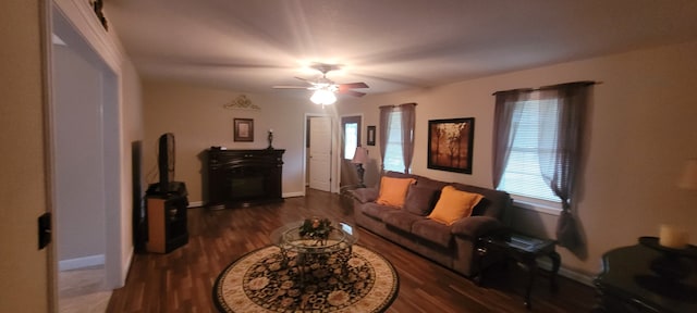 living room with dark wood-type flooring and ceiling fan