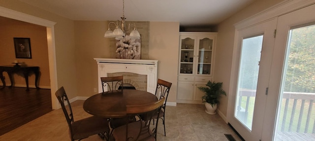 104 Oak Crest Dr, Tennessee Ridge, TN 37178 - dining area featuring a chandelier, healthy amount of natural light, a fireplace, and baseboards