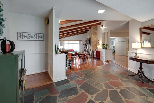 corridor with vaulted ceiling with beams