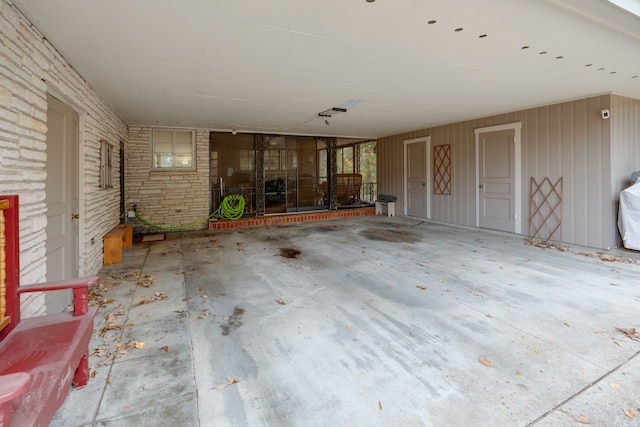 unfurnished living room featuring wooden walls