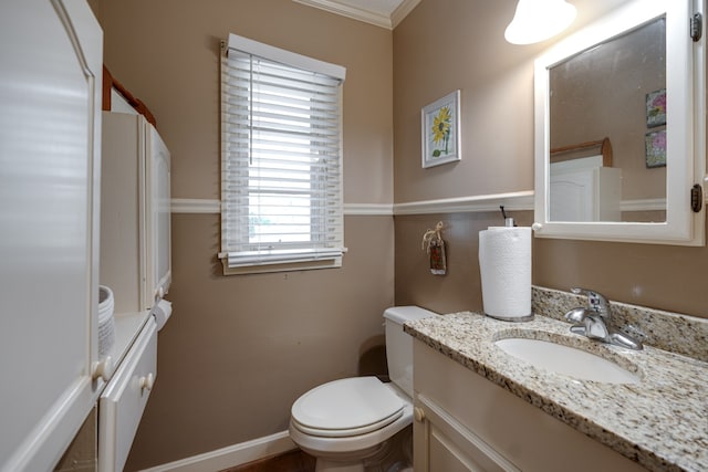 bathroom with vanity, toilet, and crown molding