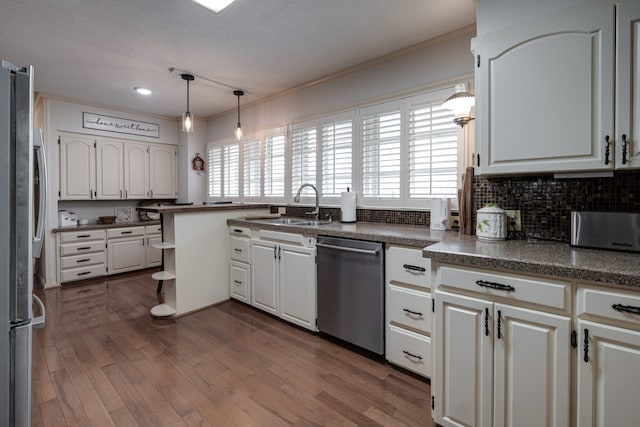 kitchen featuring white cabinetry, sink, hardwood / wood-style floors, and appliances with stainless steel finishes