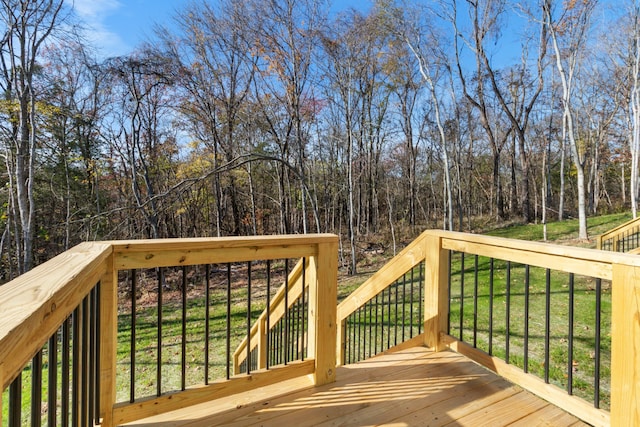 wooden deck featuring a lawn