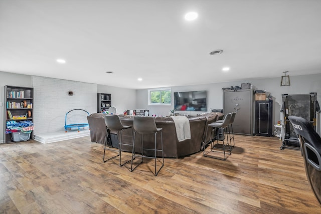 living room featuring bar area and light hardwood / wood-style flooring