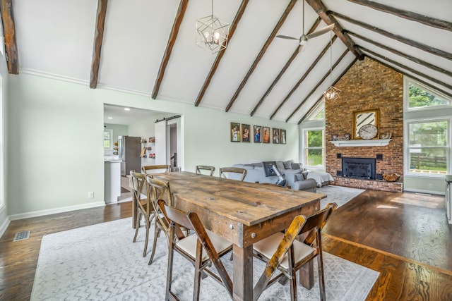 dining room with high vaulted ceiling, wood-type flooring, a barn door, and beam ceiling