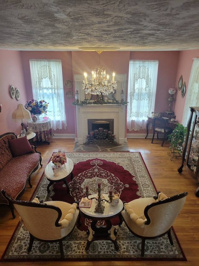 living room with hardwood / wood-style flooring, an inviting chandelier, and plenty of natural light