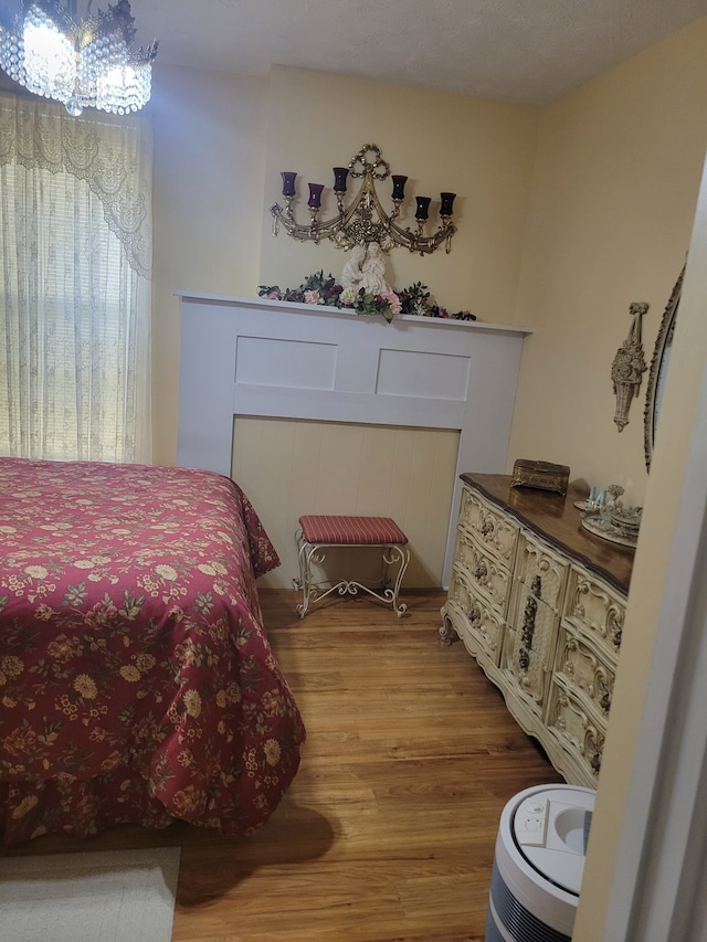 bedroom featuring a chandelier, hardwood / wood-style flooring, and a textured ceiling