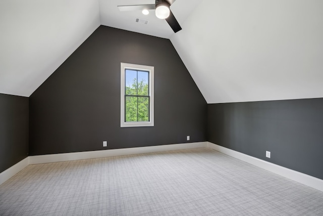 additional living space with ceiling fan, light colored carpet, and vaulted ceiling