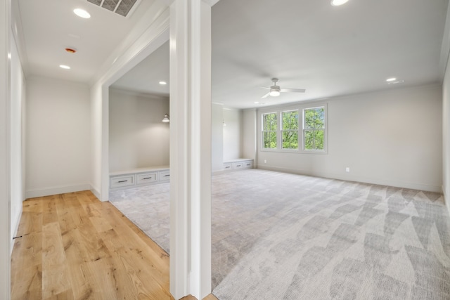 hallway with ornamental molding and light wood-type flooring