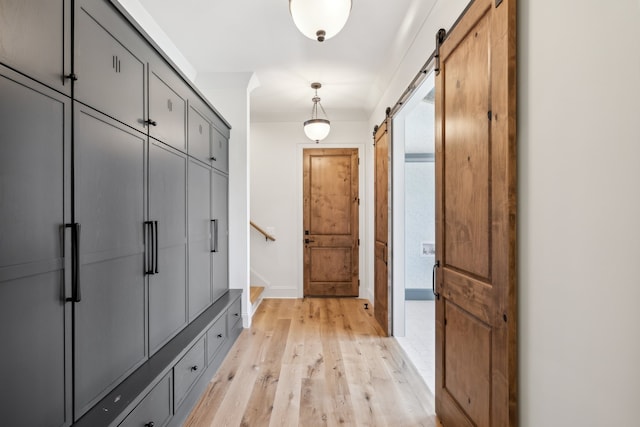 mudroom featuring a barn door and light wood-type flooring