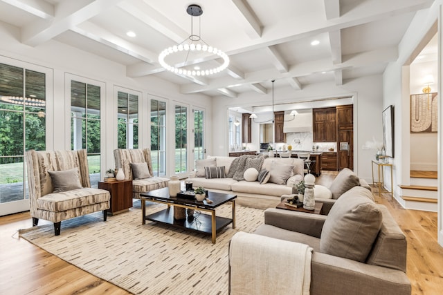 living room featuring light hardwood / wood-style floors, beam ceiling, and a chandelier