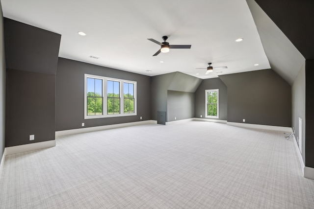 empty room with ceiling fan, light carpet, lofted ceiling, and a wealth of natural light