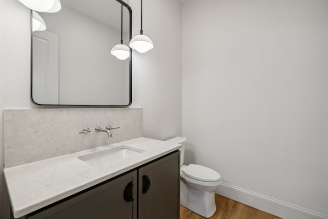 bathroom with vanity, toilet, and hardwood / wood-style flooring