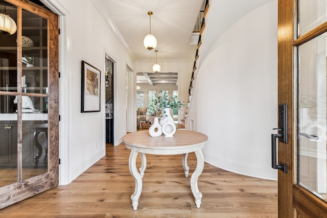 foyer entrance with crown molding and light wood-type flooring