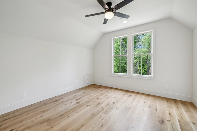 additional living space with ceiling fan, lofted ceiling, and light wood-type flooring