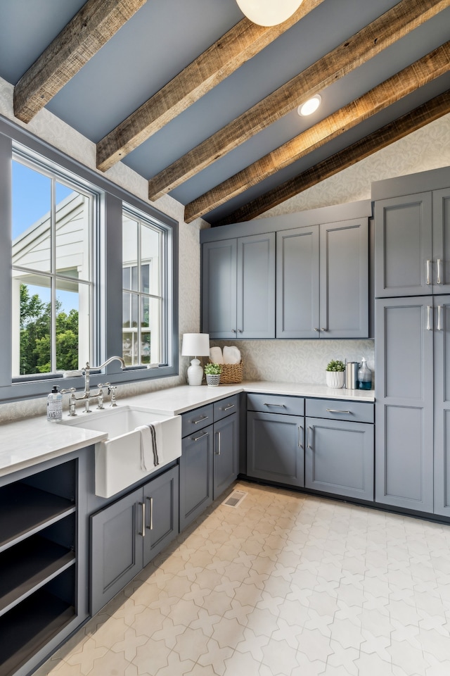 kitchen featuring lofted ceiling with beams, tasteful backsplash, sink, and gray cabinets