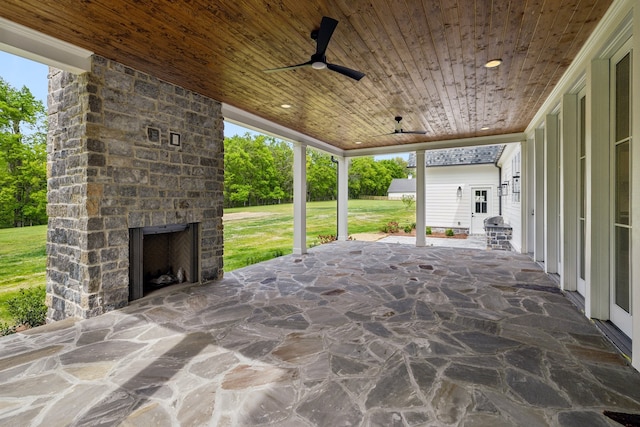 view of patio / terrace with an outdoor stone fireplace and ceiling fan