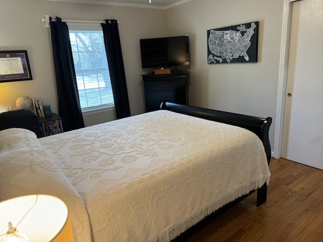 bedroom with crown molding and wood-type flooring