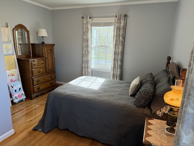 bedroom with crown molding and light hardwood / wood-style flooring