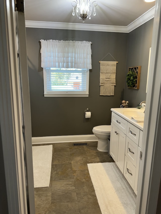 bathroom featuring crown molding, vanity, toilet, and an inviting chandelier