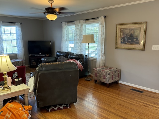 living room with hardwood / wood-style flooring, ornamental molding, plenty of natural light, and ceiling fan