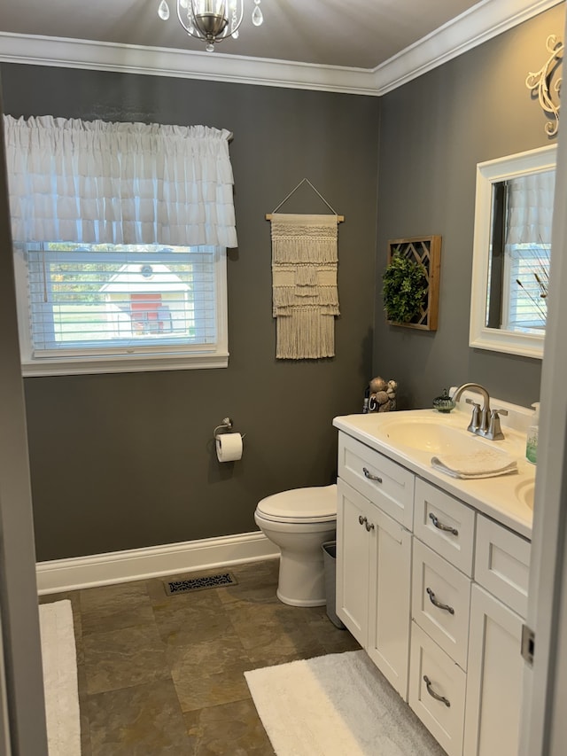 bathroom with ornamental molding, vanity, and toilet