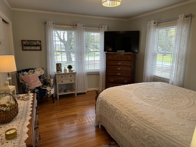 bedroom with hardwood / wood-style flooring and ornamental molding