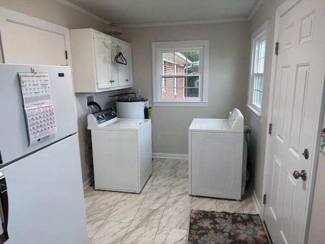 clothes washing area featuring water heater, independent washer and dryer, ornamental molding, and cabinets