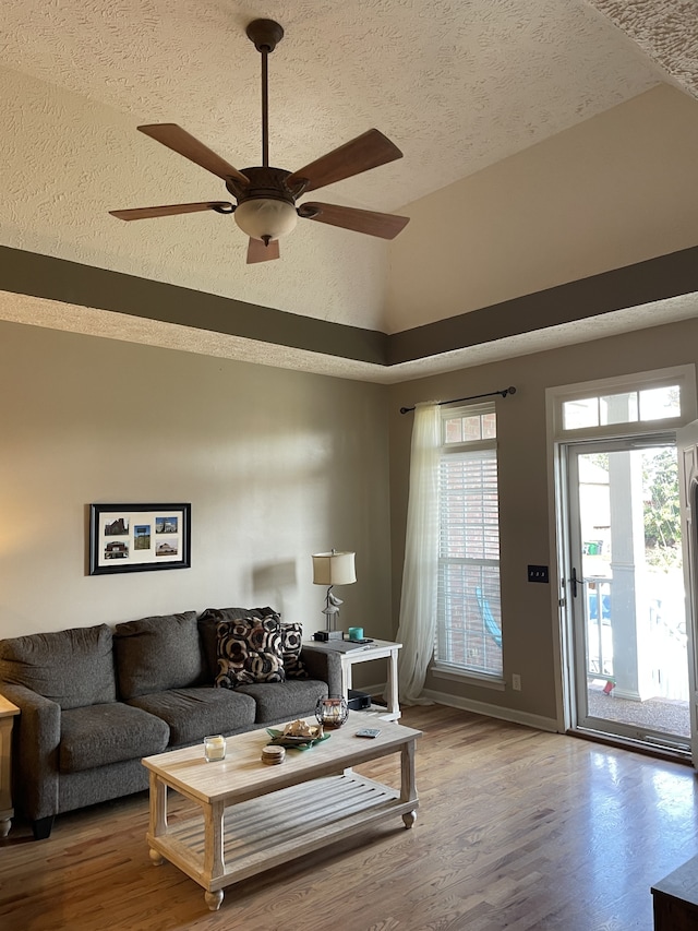 living room featuring hardwood / wood-style floors, a textured ceiling, and ceiling fan