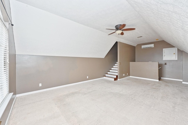 bonus room featuring ceiling fan, lofted ceiling, light carpet, and a textured ceiling