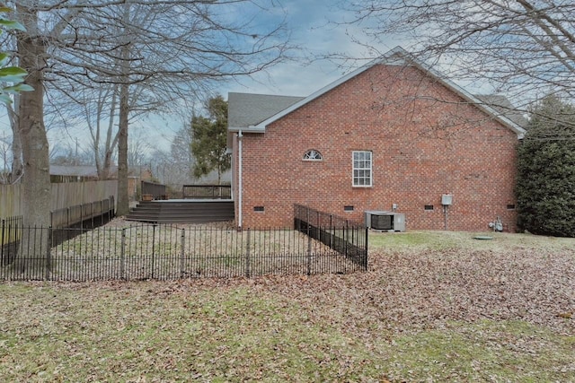 view of side of property featuring a yard and central AC unit