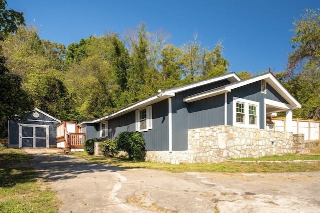 view of side of home with a storage shed and a deck