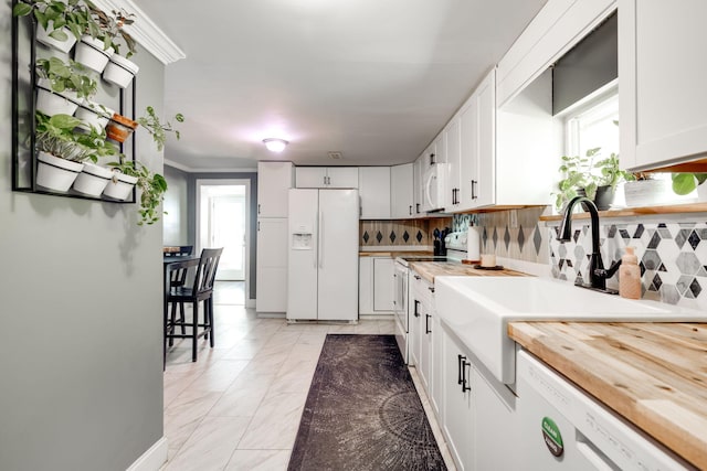 kitchen with decorative backsplash, white cabinetry, sink, and white appliances