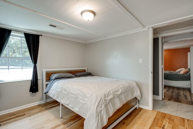 bedroom featuring ornamental molding and wood-type flooring