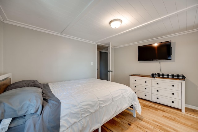 bedroom featuring crown molding and light hardwood / wood-style flooring