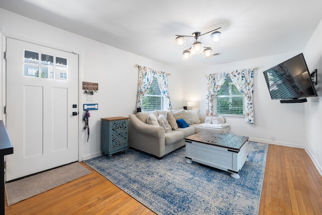 living room featuring an inviting chandelier, hardwood / wood-style floors, and plenty of natural light